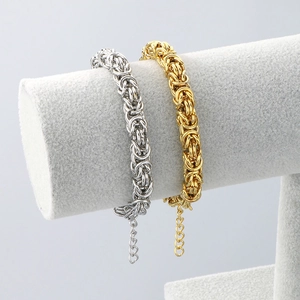 Byzantine chain bracelets in gold and silver finish on a premium grey jewelry display stand