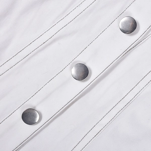 Dettaglio del tessuto twill bianco con bottoni in metallo argento e cuciture nere