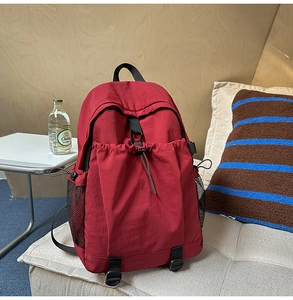 Detailansicht eines großen roten Nylon-Rucksacks mit Kordelzug-Fronttasche und Netztaschen