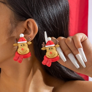 Détail macro de boucles d'oreilles renne en résine avec bonnet et écharpe de Noël