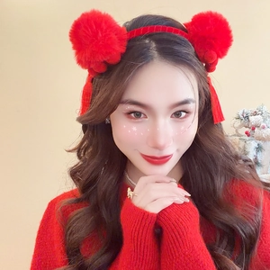 Detailed view of red plush pom-poms and elegant tassels on a festive holiday headband