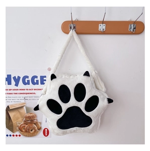 Close-up of white plush cat paw bag with black paw pads and matching shoulder strap