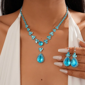 Luxury blue teardrop crystal necklace and earrings set worn with an elegant white gown