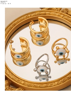 Detailansicht des Evil Eye Schmucksets mit gehämmerten Goldohrringen auf Spiegel