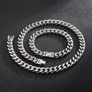 Nahaufnahme von silberner Panzerkette und Armband Set mit Kastenverschluss auf schwarzem Grund