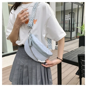 Detail of light blue crescent crossbody bag with pearl chain and jacquard strap