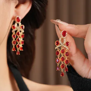 Vintage gouden oorbellen met rode zirkoon kwastjes en luxe strass knoop ontwerp