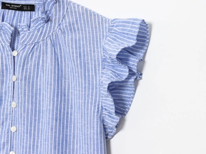 Détail d'une chemise à rayures bleues et blanches avec poignets à volants et col boutonné