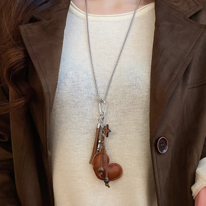 Close-up of leather heart and star pendants with tassels on a long sweater necklace