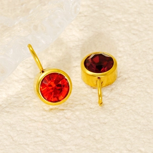 Close-up of gold-rimmed ruby gemstone stud earrings with multi-faceted cut finish