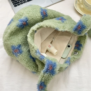 Detail of floral plush bucket bag interior showing magnet clasp and zipper pocket