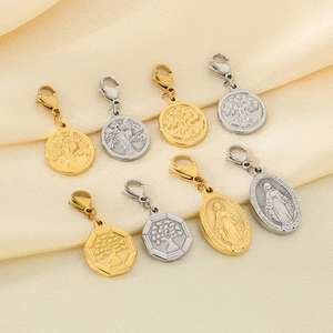 Detailed view of silver and gold tree of life pendants on silk fabric background