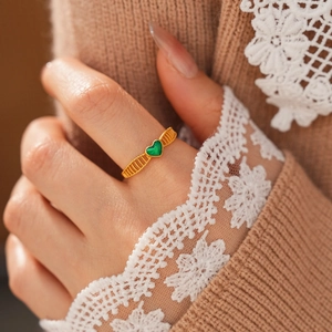 Bague vintage dorée avec pierre verte en cœur et détails ajourés sur l'anneau doré