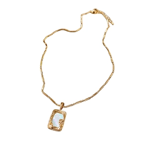Gold plated square pendant necklace with white mother of pearl inlay and ornate accents