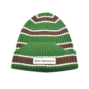 Striped knit beanie hat in green, brown and white stripes with rectangular patch label