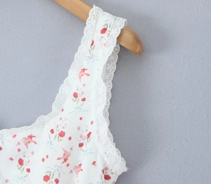 Primer plano detallado del ribete de encaje blanco y patrones florales en el vestido