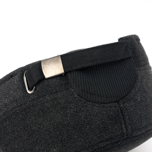 Detail of wool flat cap back showing adjustable metal buckle and herringbone texture