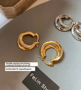 Detail of gold and silver double-layered geometric hoop earrings with pave rhinestones