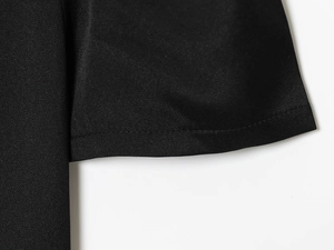 Vue macro détaillée de la texture du tissu synthétique noir et des coutures de l'ourlet