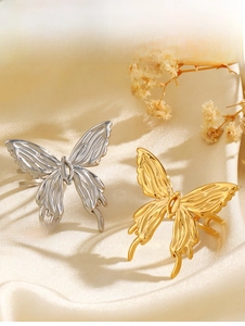 Detailed macro view of gold and silver butterfly rings with liquid metal texture finish
