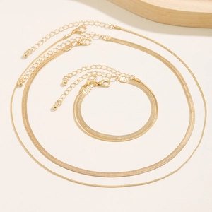 Detailed view of layered gold snake chain necklaces and matching bracelet set