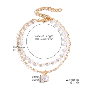 Detail shot of golden double-layer bracelet with pearls and circular pendant size specs