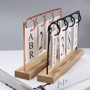 Detail of Nordic wooden desk calendar with metal frames in rose gold and black finish