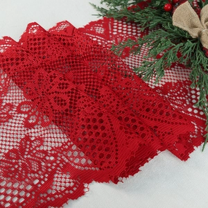 Red Christmas lace table runner with heart patterns and festive pine decorations