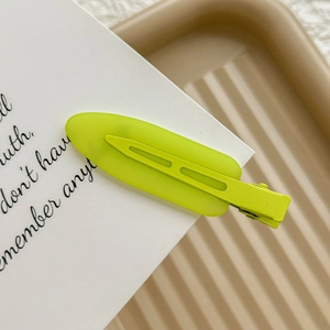 Close-up of a matte fluorescent green seamless hair clip on a white display card
