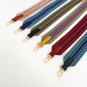 Colorful wide woven shoulder straps with geometric patterns and gold metal lobster clasps