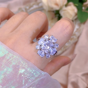 Detailed view of luxury sunflower zircon ring with oval center stone on model's finger
