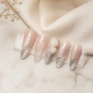 Detailed view of long stiletto nails with 3D white roses and marble patterns