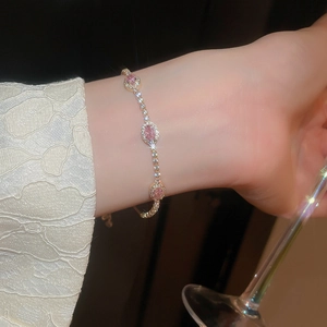 Detail of elegant gold bracelet featuring three oval pink zircons and sparkling crystals