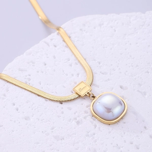 Detailed macro view of gold-plated snake chain with a square iridescent pendant and Love tag