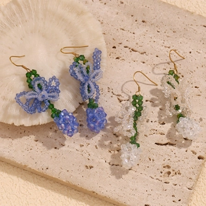 Detailed view of handmade crystal beaded lily of the valley earrings with gold hooks
