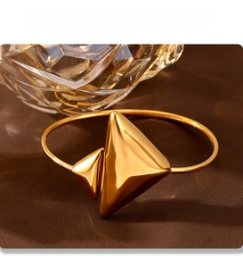 Macro detail of 18K gold-plated stainless steel triangle bracelet with PVD finish