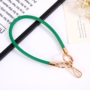 Close-up of green PU leather wrist strap with high-quality gold metal lobster clasp