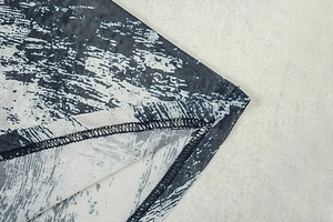 Macro detail of abstract black and white print fabric with precise overlock stitching