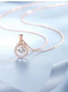 Macro del ciondolo a cerchi intrecciati oro rosa con zircone centrale danzante