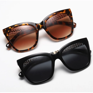 Detail of cat eye sunglasses showing tortoiseshell frames and metal chain temple accents