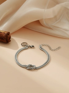 Detail of silver double-layer chain bracelet with central knot and adjustable clasp