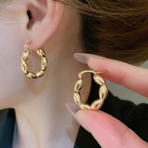 Detailed macro view showing the S925 hallmark on gold-plated twisted croissant hoop earrings