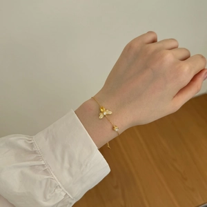 Detailed close-up of S925 sterling silver golden chain bracelet with firefly charm