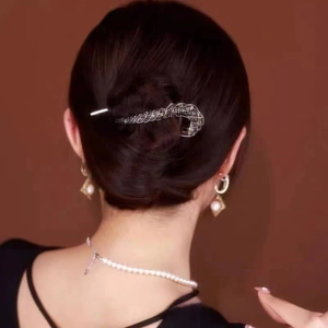 Elegant twisted hair clip with black rhinestones worn by a model in a formal hairstyle