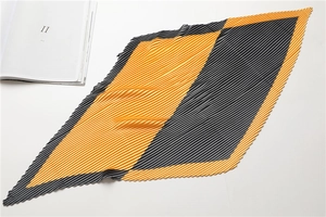 Detailed view of yellow and grey color-block pleated scarf with accordion texture