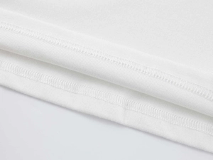 Close-up of white modal fabric with high-density double-needle stitching and fine knit texture