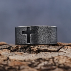 Vintage stainless steel biker ring with hollow cross design on rustic bark texture