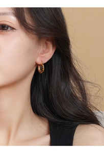 Close-up of model wearing 14k gold plated leopard print round hoop earrings in retro style