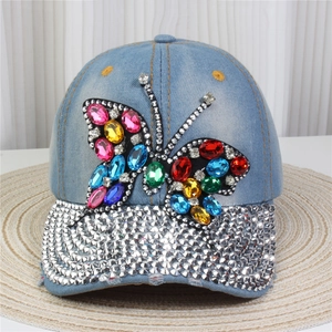 Close-up of light blue denim baseball cap with colorful rhinestone butterfly and crystal brim