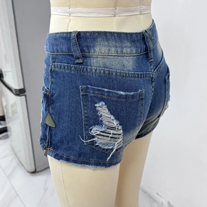 Détail du short en jean avec poches arrière déchirées et bordure zippée décorative latérale